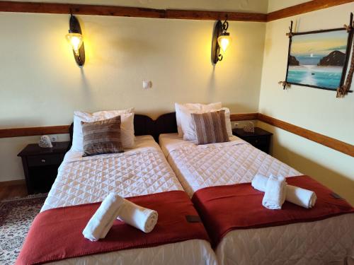 two beds sitting next to each other in a room at Prespa Resort & Spa in Platy