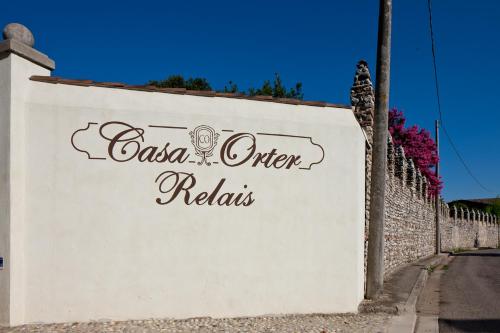 a white wall with a sign that reads casa otirrina at Relais Casa Orter in Risano