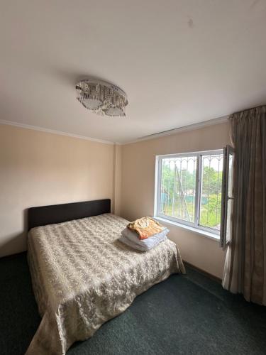 a bedroom with a bed and a window at Гостевой дом Достук in Bosteri