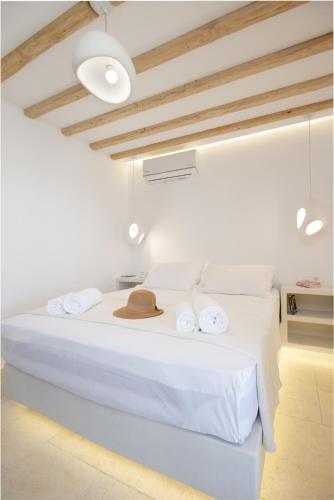 a white room with a bed with a hat on it at Ethereal House - Seafront by Cheronissos Beach in Cherronisos