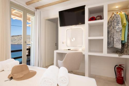 a white room with a bed and a tv at Ethereal House - Seafront by Cheronissos Beach in Cherronisos