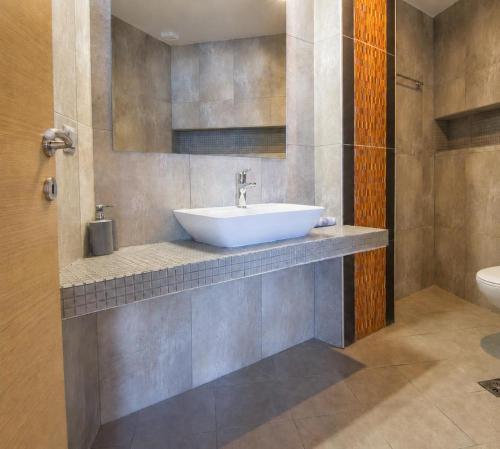 a bathroom with a sink and a toilet at Tridente Mare Apart Hotel in Pefkochori