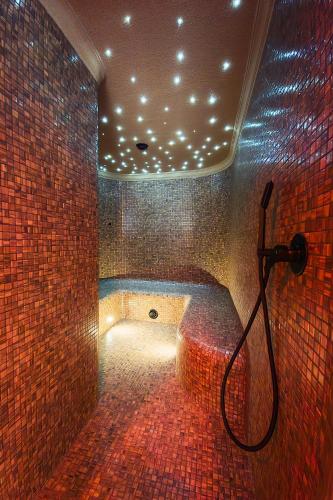 a bathroom with a bath tub in a room with bricks at Baltic Season Spa Apartments in Grzybowo