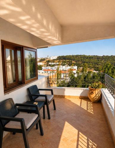 a balcony with chairs and a view of a city at Dar Tanja in Tangier