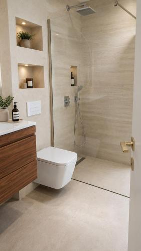 a bathroom with a white toilet and a shower at White Hills Villa in Zadar