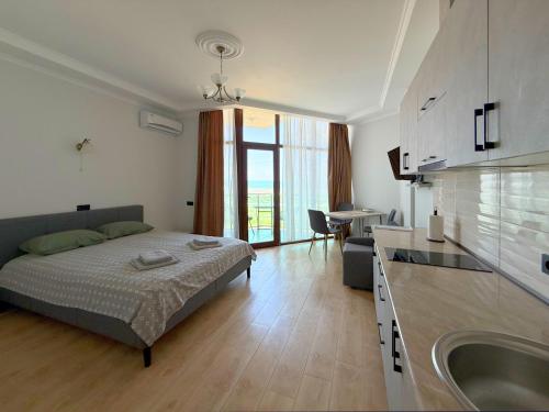 ein Schlafzimmer mit einem Bett und eine Küche mit Spüle in der Unterkunft SofiCoast in Gonio