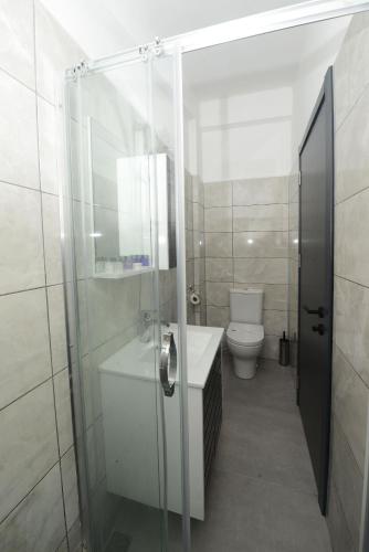 a bathroom with a glass shower and a toilet at Otel Diyojen in Sinop