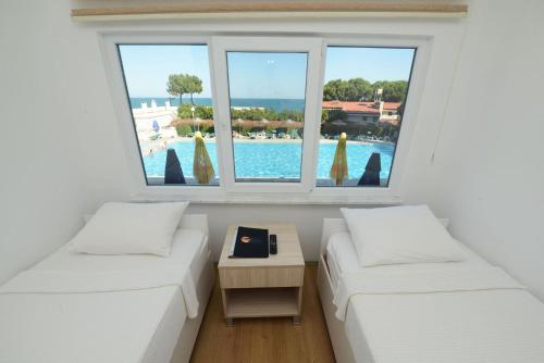 two beds in a room with a view of a pool at Otel Diyojen in Sinop