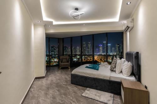 a bedroom with a large window with a city skyline at FLORIA - Sky Suites in Accra