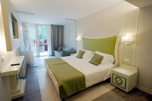 a bedroom with a large bed with a green headboard at Majestic Palace in Malcesine