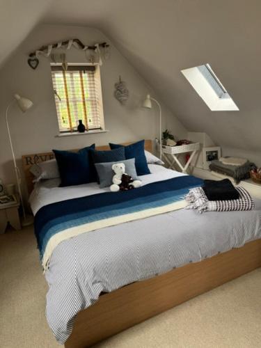 a bedroom with a large bed with a teddy bear on it at The Annexe in Chipping Campden
