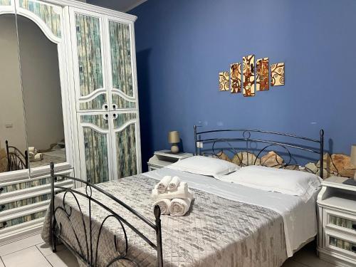 a blue bedroom with a bed with towels on it at Estía Holidays Apartments - Taormina in Taormina
