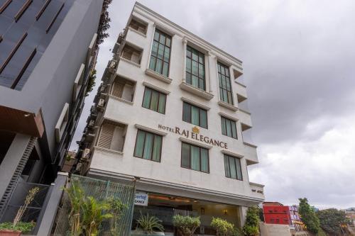 a white building with a sign on it at Treebo Premium Raj Elegance Manyata Tech Park in Bangalore