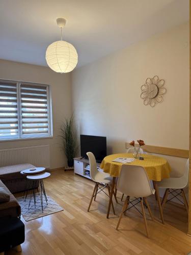 a living room with a dining room table and chairs at Apartman Ninolić in Jagodina