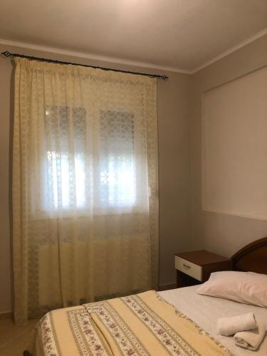 a bedroom with a bed and a window with curtains at Villa Dream in Karianí