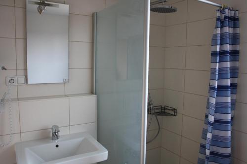 a bathroom with a sink and a shower at Pension Kirchenwirt in Niederaichbach