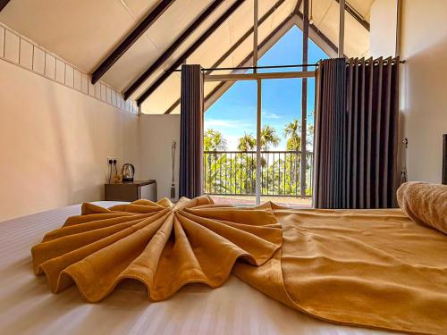a bedroom with a large bed with a large window at Tera Ella Boutique Hotel by SANS in Ella