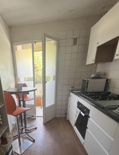 a kitchen with a table and a stove top oven at Chambre double Greg en colocation in Montpellier