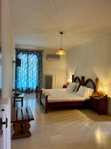 a bedroom with a bed and a large window at Hotel Marialena in Ancient Epidauros