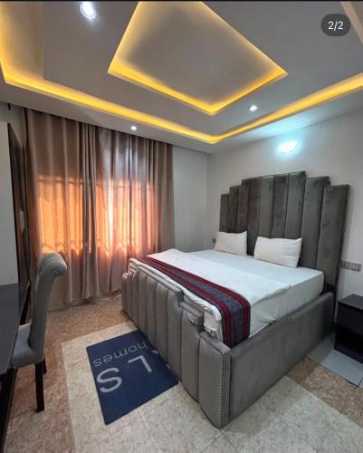 a bedroom with a bed and a desk in a room at Homelands in Port Harcourt