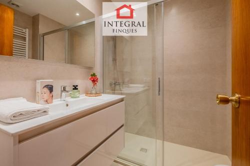 a bathroom with a shower and a white sink at Casa Norai in Palamós