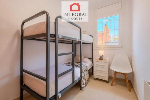 a bedroom with two bunk beds and a desk at Casa Norai in Palamós