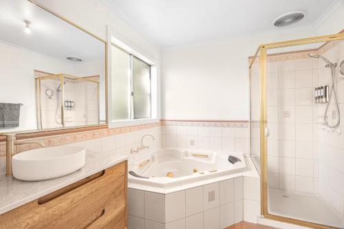a bathroom with a tub and a sink and a shower at The Lakeview in Lilydale