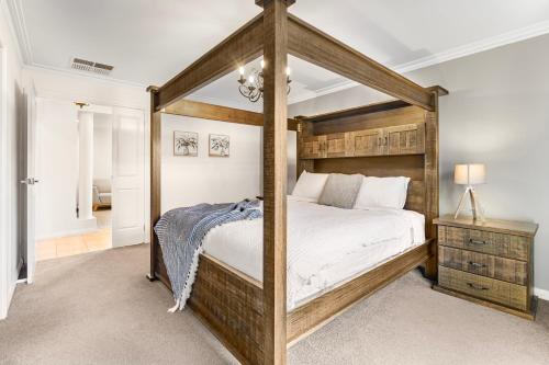 a bedroom with a wooden canopy bed in a room at The Lakeview in Lilydale