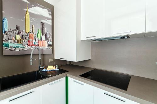 a kitchen with white cabinets and a picture of a city at Il Sogno di Angelo - Blevio in Blevio