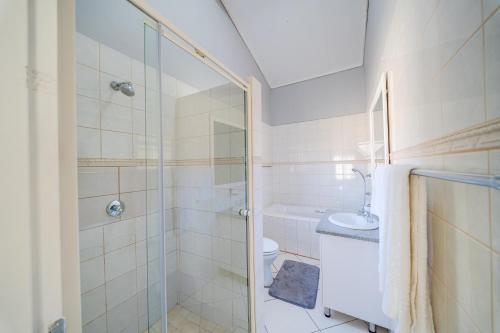 a bathroom with a shower and a toilet and a sink at 22 on Nicol in Secunda