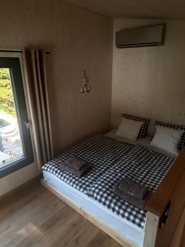 a bed in a small room with a window at Glamping Hynkov in Příkazy