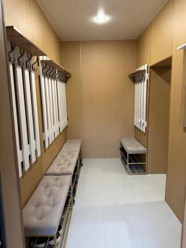 a locker room with rows of benches and windows at Отдых у речки in Almaty