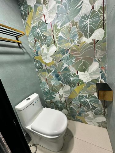 a bathroom with a toilet and a flowery wall at A.C. Asistin Transient House in Baguio