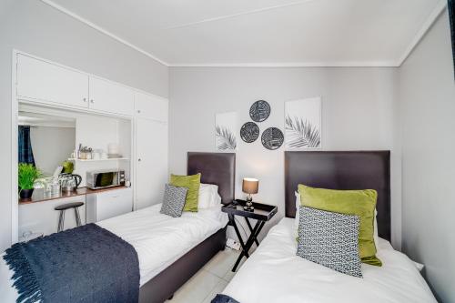 a bedroom with two beds and a desk in it at 22 on Nicol in Secunda