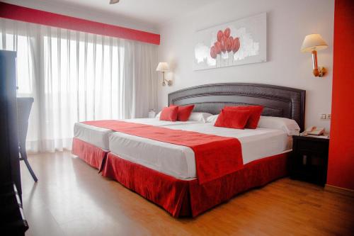 a hotel room with a large bed with red accents at Senator Marbella in Marbella