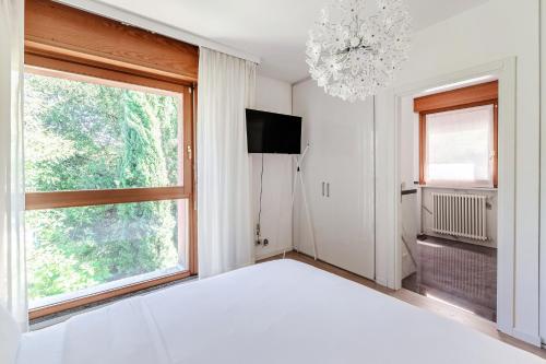 a bedroom with a bed and a large window at Il Sogno di Angelo - Blevio in Blevio