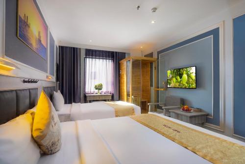 a hotel room with two beds and a television at Ruby Luxury Hotel in Nha Trang