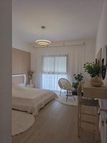 a bedroom with a bed and a table and a window at Superbe appartement à marina Tanger in Tangier