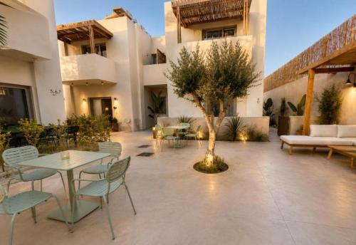 a courtyard with a table and chairs and a tree at MIRA MARE - Apartment 5 in Stavros