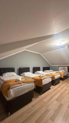 a row of beds in a room with wooden floors at Kuzey Suite Otel in Uzungöl
