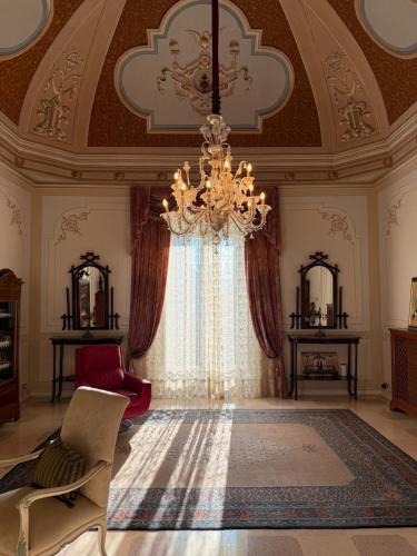 a large room with a chandelier and a large window at Palazzo Rodio in Ostuni
