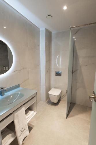 a bathroom with a sink and a toilet and a shower at White Amfora Hotel in Shëngjin