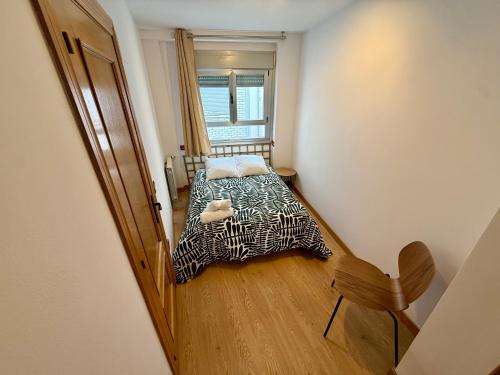 a small bedroom with a bed and a window at Lotila Flats Oviedo in Oviedo