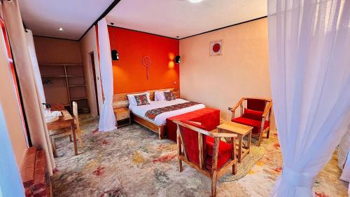 a bedroom with a bed and a red wall at Enjipai Ngorongoro Lodge in Karatu