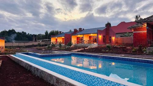 a large swimming pool in front of a house at Enjipai Ngorongoro Lodge in Karatu