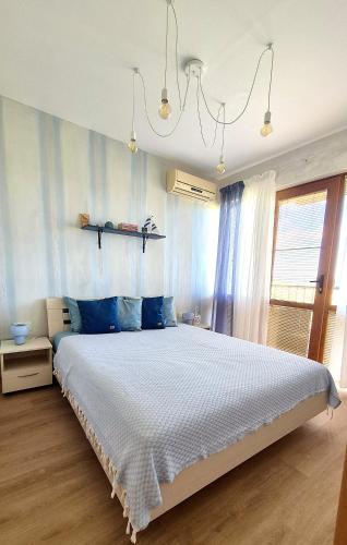 a bedroom with a large bed with blue pillows at Seaside Dream in Dolen Bliznak