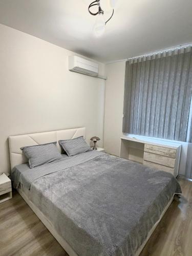 a bedroom with a large bed and a window at Cozy Home 2 Bedroom apartment in Kyustendil