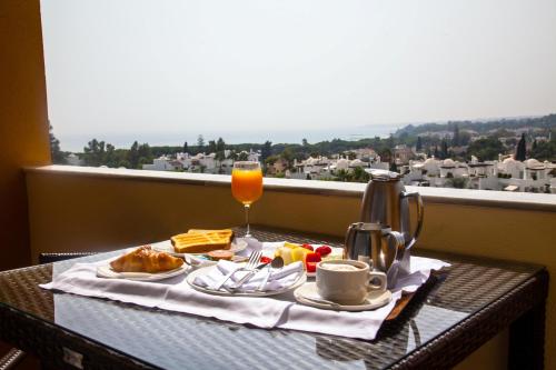 a table with a tray of food and a glass of orange juice at Senator Marbella in Marbella