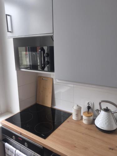 a kitchen with a stove and a counter top at Apartament Pastelowy Kwidzyn in Kwidzyn