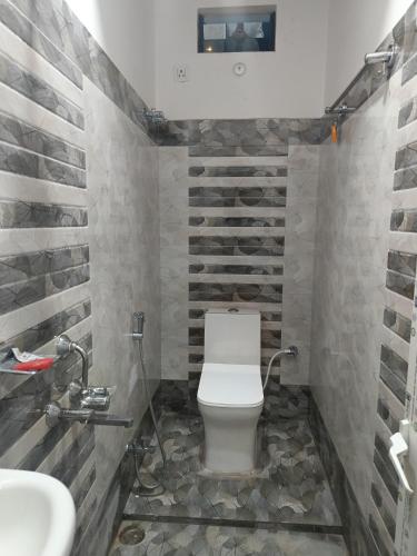 a bathroom with a toilet and a sink at Hotel Malik Palace in Noāmundi